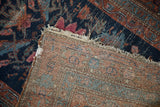 Detailed view of hand-knotted back weave and worn navy, raspberry, teal floral pile.