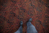 Hand-knotted Ersari pile texture: geometric gul medallions, dusty red, navy, copper tones.