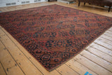 Antique Ersari carpet displaying dusty red and navy gul and starburst medallions, with even wear.