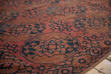 Close-up of antique Ersari hand-knotted carpet, dusty red and navy geometric gul medallions, even wear.