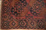 Antique Ersari carpet corner: serrated floral border in dusty red and navy, with visible wear.