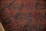 Detail of Ersari antique rug showing dusty raspberry red, navy blue gul medallions, even wear.