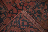 Dusty raspberry fringe and worn pile of an antique Ersari rug, featuring navy gul motifs.