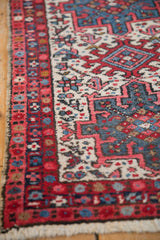 Close detail of a vintage Karaja rug's hand-knotted texture in the red and blue geometric border.