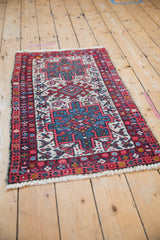 Angled view of the vintage Karaja Persian rug's bold geometric triple medallion pattern.