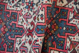 Textured hand-knotted pile of a vintage Karaja rug with red, blue, and ivory hook and latch motifs.