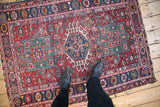 Covered field of geometric blossoms and checkered designs on a Karaja rug.