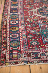 Vintage Karaja rug showing geometric borders and cherry red field with aged edges.