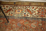 Antique Bakshaish rug's worn red field, blue stripe, and distinct cream and camel borders.