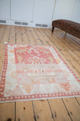 Vintage distressed Oushak rug detail, highlighting heavy abrash in pale raspberry and ivory.