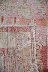 Distressed vintage Oushak rug's hand-knotted reverse, fringe, and pale abrash pile.