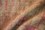 Textured weave with hot pink decorative lines on a distressed vintage Oushak rug.