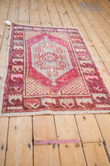 Distressed Oushak rug corner with germinating seed motif in fuchsia, beige, and tangerine.