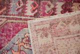 Distressed fuchsia and beige Oushak rug pile revealing knot heads and hand-knotted reverse.