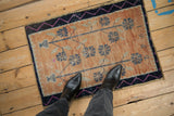 Corner detail of distressed vintage Oushak rug with navy border and fuchsia zig-zag.