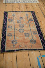 Vintage Oushak rug detail: '1962' date, tangerine field, navy floral blossoms, fuchsia zig-zag border.