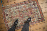 Vintage distressed Oushak rug showing playful starbursts in dusty aubergine, jade, and orange.