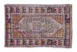 Distressed vintage Oushak rug with faded floral medallion, worn violet, gold, and blue hues, 2'8