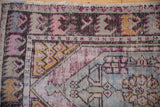 Distressed Oushak corner detail with gold seed motif and faded violet tones.