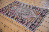 Distressed gold seed motif corner and faded blue floral medallion detail on Oushak.