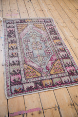 Distressed vintage Oushak rug medallion with checkered floral bouquet in blue, pink, and gold.