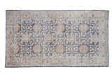 Vintage distressed Sparta rug with a floral trellis design in denim blue, ivory, and dusty sandalwood.