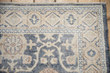 Corner view of a worn Sparta rug with blue and sandalwood floral motifs and border.