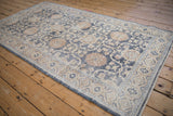Full-length angle of the distressed Sparta rug's floral trellis pattern in denim blue and ivory.