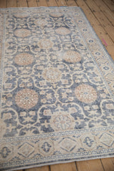 Angled view of a vintage distressed Sparta rug's floral trellis pattern in denim blue and sandalwood.