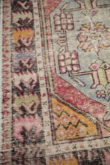 Saffron yellow corner spandrel and geometric border motifs with exposed foundation on a vintage Oushak rug.