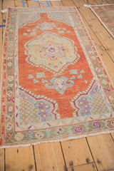Perspective view of a distressed Oushak runner with a rust field, pale blue accents, and center medallion.