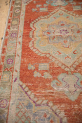 Close view of the distressed, hand-knotted pile and worn texture on a vintage Oushak runner.