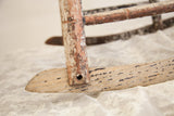 Primitive children's rocking chair's aged wood, chipped paint, and dowel hole.
