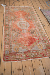 Distressed Oushak runner's textured pile, with mostly even wear, visible foundation, and muted floral details.