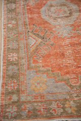Distressed Oushak rug runner border with pinwheel stylized flowers in pale coffee brown and slate blue.