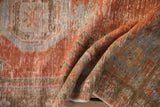 Distressed vintage Oushak runner texture with visible wear, featuring rust and slate blue.