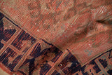 Distressed vintage Oushak rug, geometric navy Lotto border on tomato red field.