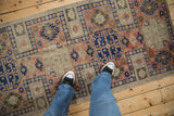 Vintage distressed Anatolian runner with worn pile, primitive guls, blush, and cobalt blue.