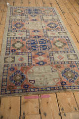 Detail of distressed Anatolian runner showing geometric guls, blush, cobalt blue, and ivory, with even wear.
