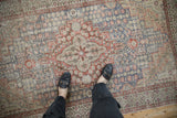 Faded slate blue, terracotta starburst motifs on a distressed vintage Sivas rug.