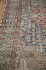 Muted slate blue, brick red, and sand starburst patterns on a distressed Sivas rug.