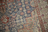 Worn Sivas rug texture, showing faded slate blue and terracotta starbursts.