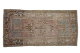 Distressed vintage Oushak runner, elongated medallion and arabesque border, faded mauve, blue, and olive.