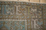 Worn pile and motifs on a distressed Oushak runner with dusty blue, olive green tones.