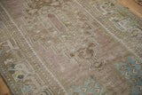 Distressed Oushak runner's textured pile showing wear and soft mauve, blue, green hues.