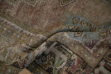 Distressed Oushak rug pile showing muted mauve, olive, and dusty sky blue tones.