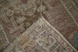 Distressed vintage Oushak rug pile worn to foundation, highlighting side selvages and muted tones.