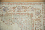 Distressed Turkish Kayseri rug corner with soft ivory and dusty rose scrolling arabesques and decorative borders.