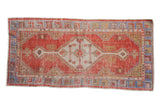Vintage distressed Oushak rug runner, brick red, ivory medallion, faded blue borders.