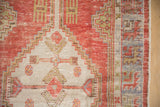 Distressed brick red Oushak rug with stepped ivory motifs and serrated green border.